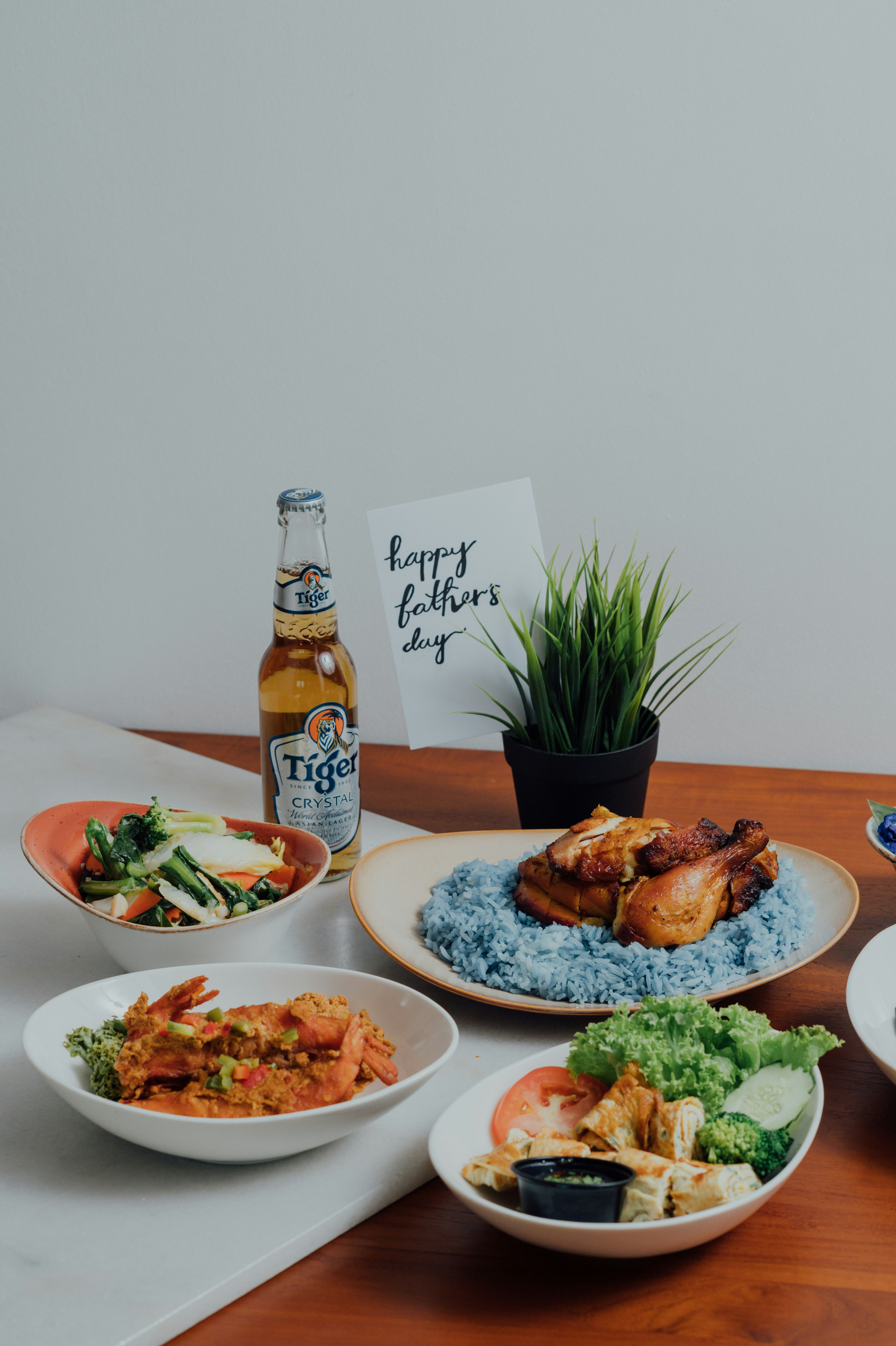 cooked food on white ceramic plate beside brown glass bottle on brown wooden table